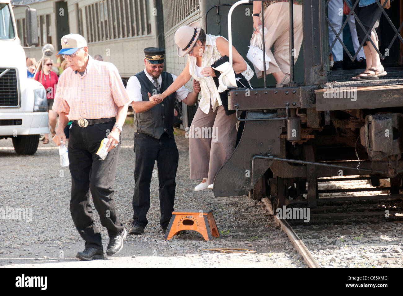 Begleiter helfen Senioren aus Waggon. Stockfoto