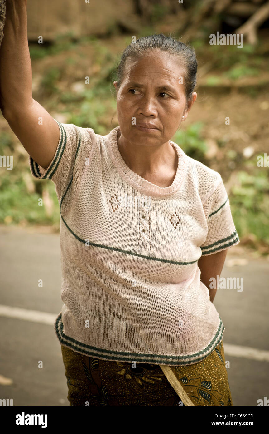 Reife asiatische Frau posiert, im Hintergrund verwüstet im Slum-Gebiet von Bali. Stockfoto