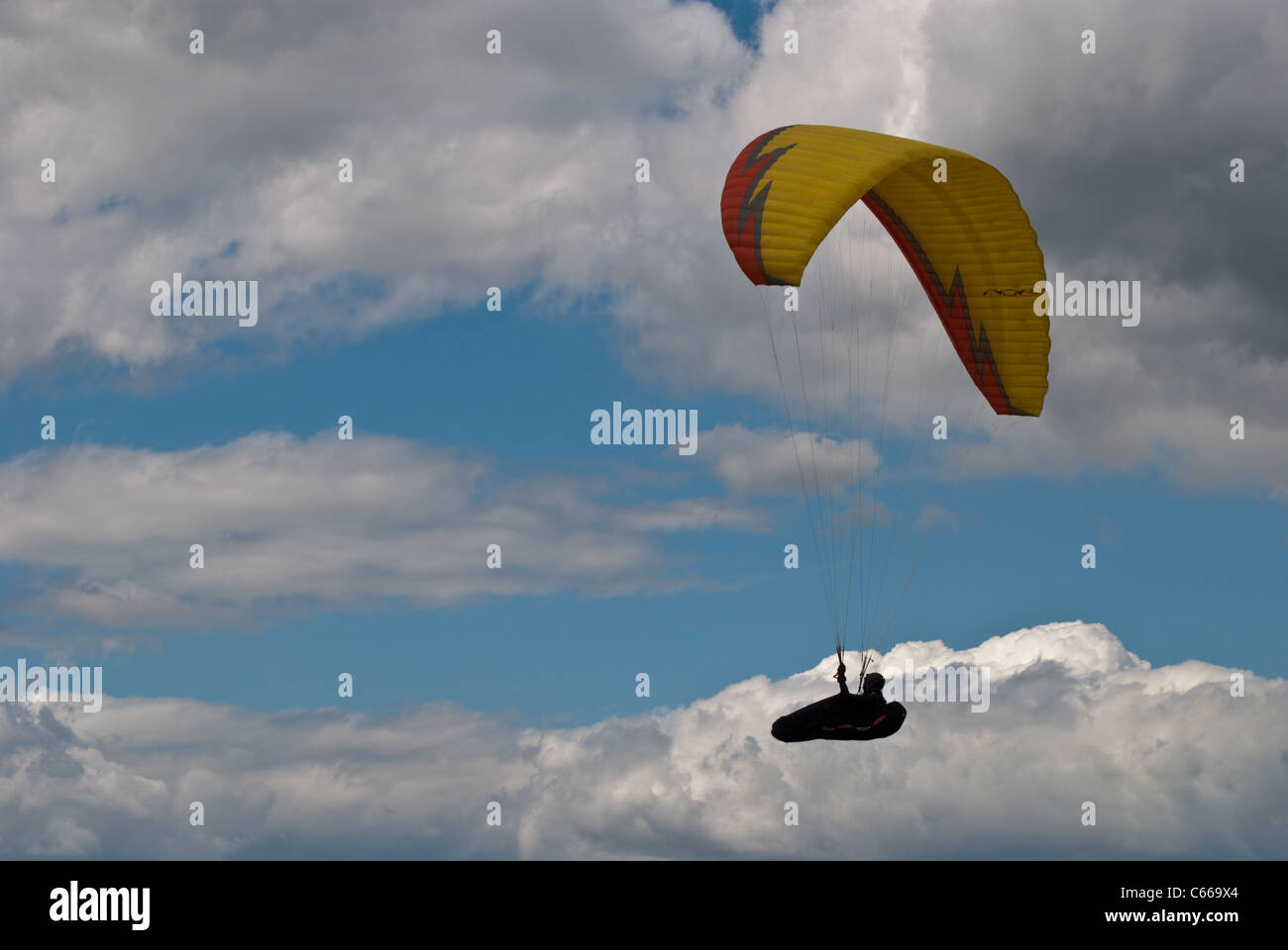 Oben in der Luft gleitet ein Gleitschirm durch einen blauen Himmel. Stockfoto