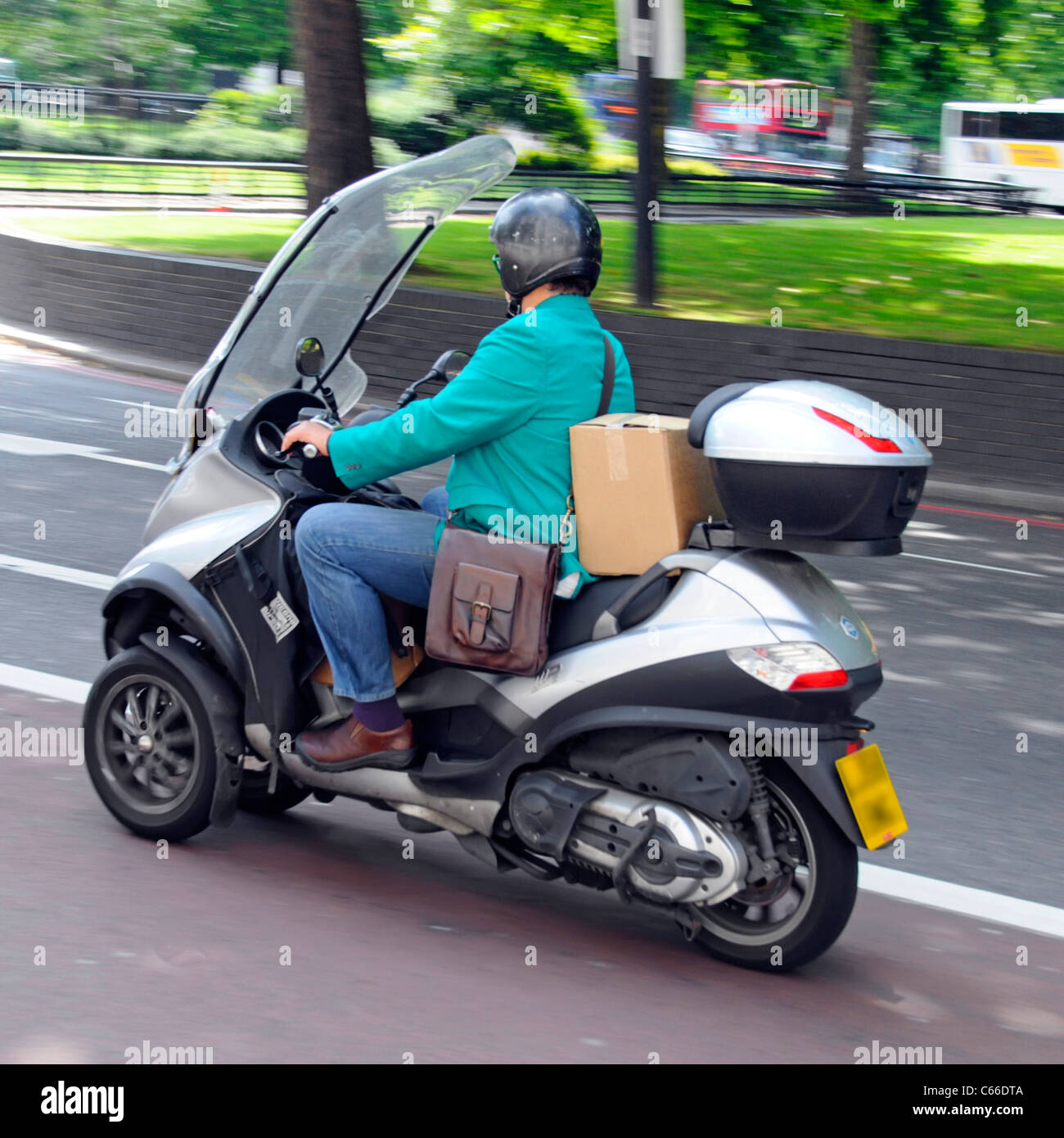 Bequeme schnelle Sommer Transport für courier Person reiten Piaggio Motorroller an Geschwindigkeit in Central London England Großbritannien reisen Stockfoto