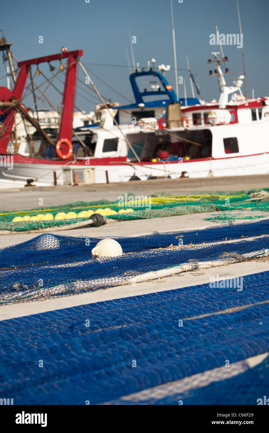 Netze ausgebreitet zum Trocknen auf Dockside, Angelboot/Fischerboot auf Hintergrund, Mallorca, Spanien Stockfoto