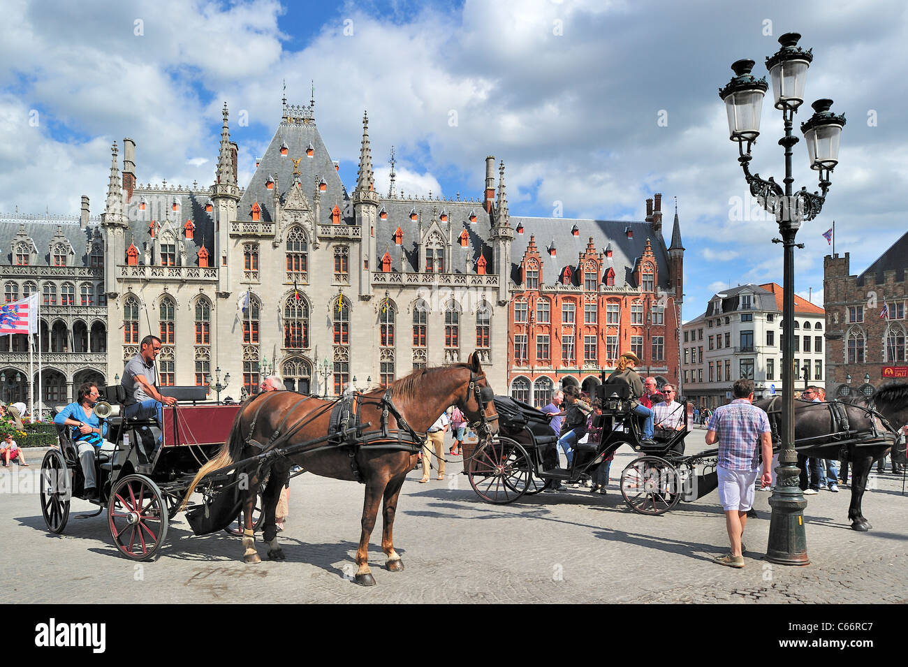 Provinzielle Gericht und Touristen in Pferdekutsche für Sightseeing-Tour auf dem Marktplatz / Grote Markt in Brügge, Belgien Stockfoto