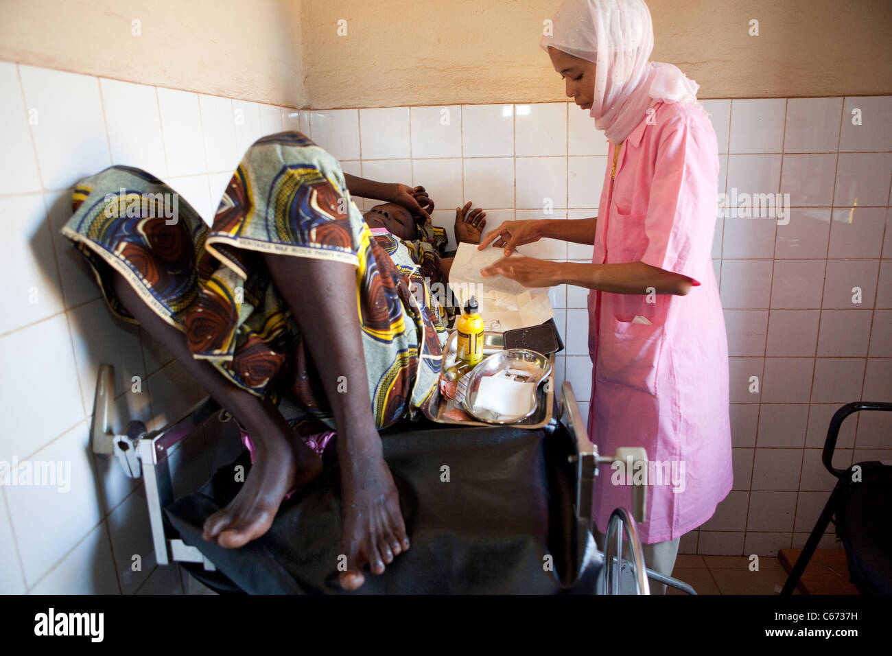 Eine Frau erhält eine empfängnisverhütende Implantat in ihren Arm in einer Klinik der reproduktiven Gesundheit in Bamako, Mali, Westafrika. Stockfoto