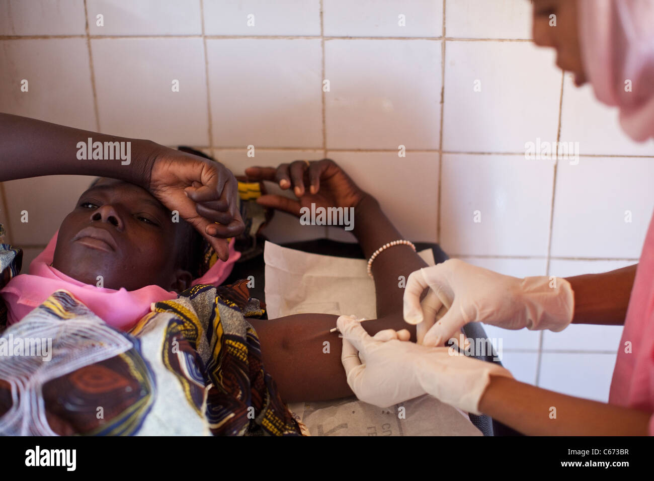 Eine Frau erhält eine empfängnisverhütende Implantat in ihren Arm in einer Klinik der reproduktiven Gesundheit in Bamako, Mali, Westafrika. Stockfoto