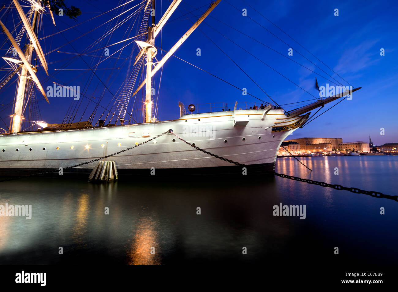 Schiff in der Nacht in Stockholm, Schweden. Stadt-Spiegelungen im Wasser Stockfoto