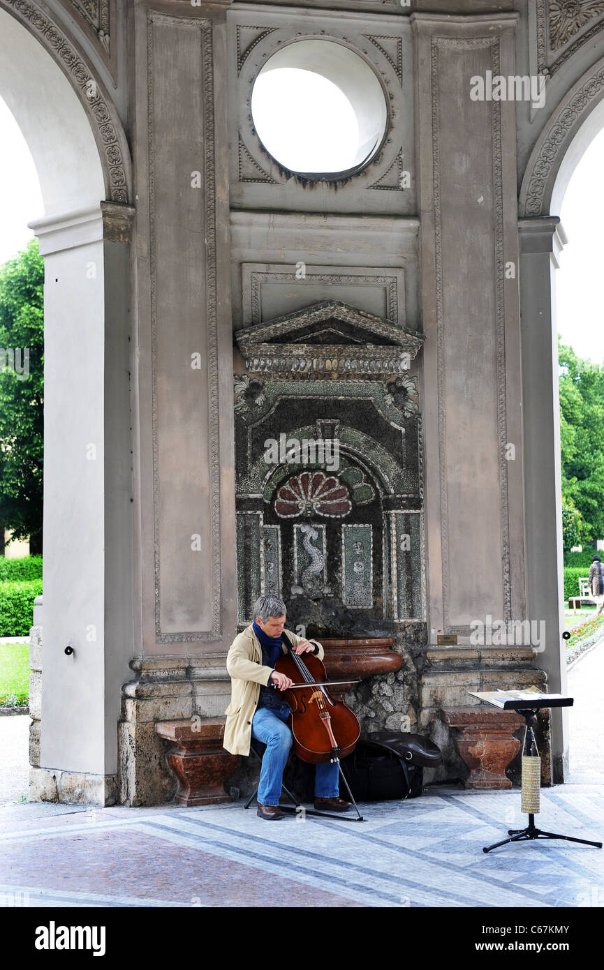 Mann als Straßenmusikant mit Cello in der Gartenlaube in der Residenz Gericht Garten München Bayern Deutschland München Deutschland Stockfoto