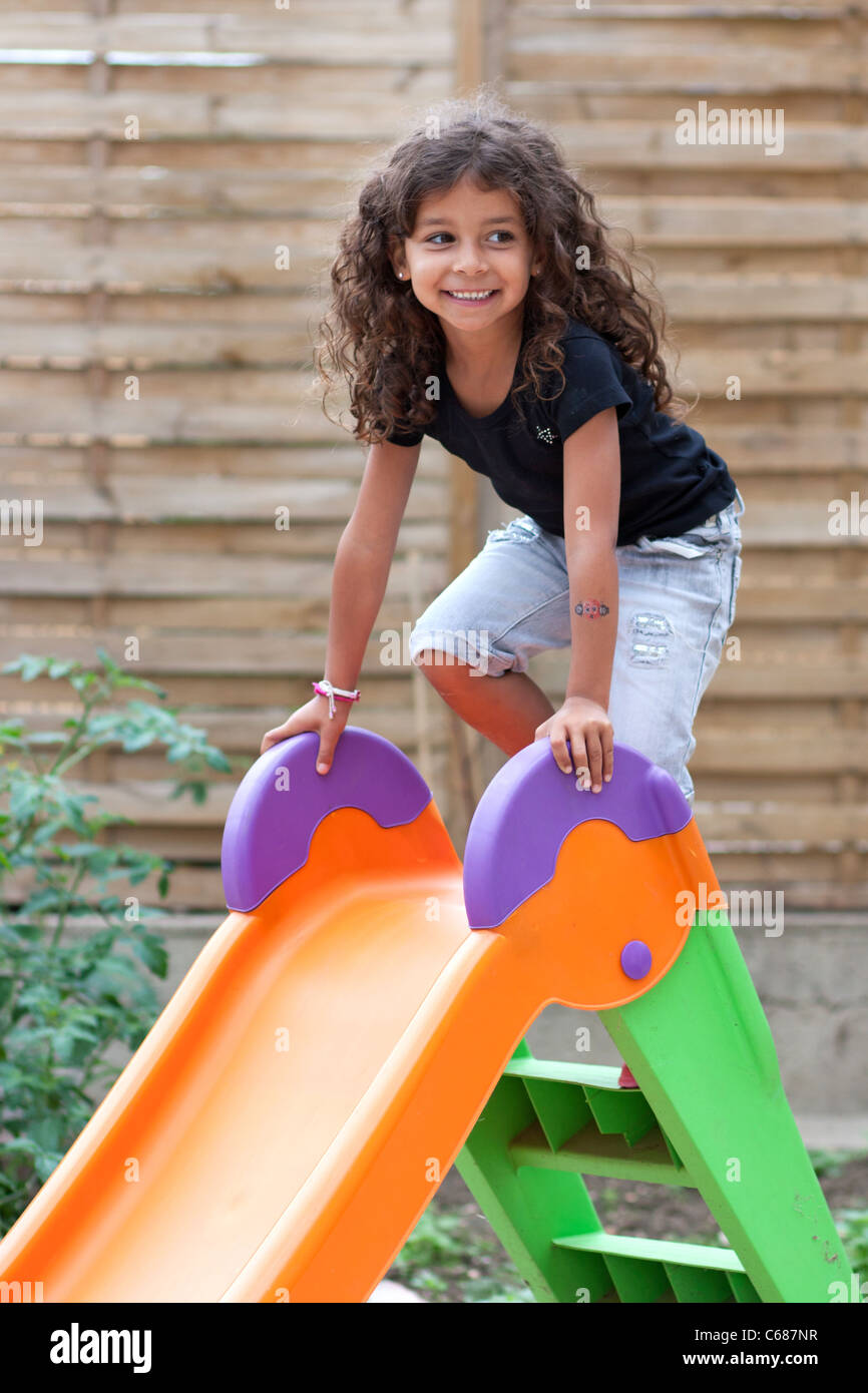 Lächelndes Mädchen spielen auf einer Folie Stockfoto