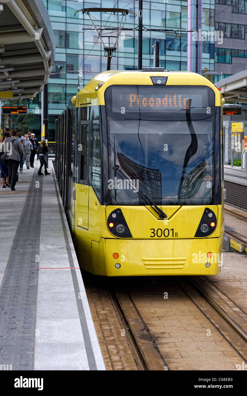 Eines der modernen gelben Straßenbahnen, stehend auf einer Plattform an der MediaCityUK Station in Salford Quays (Bestandteil der Metrolink-System) Stockfoto