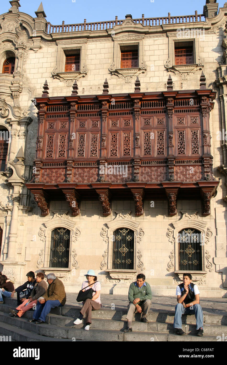 Menschen sitzen auf den Stufen des Palacio Arzobispal in der Plaza de Armas. Lima, Peru, Südamerika Stockfoto