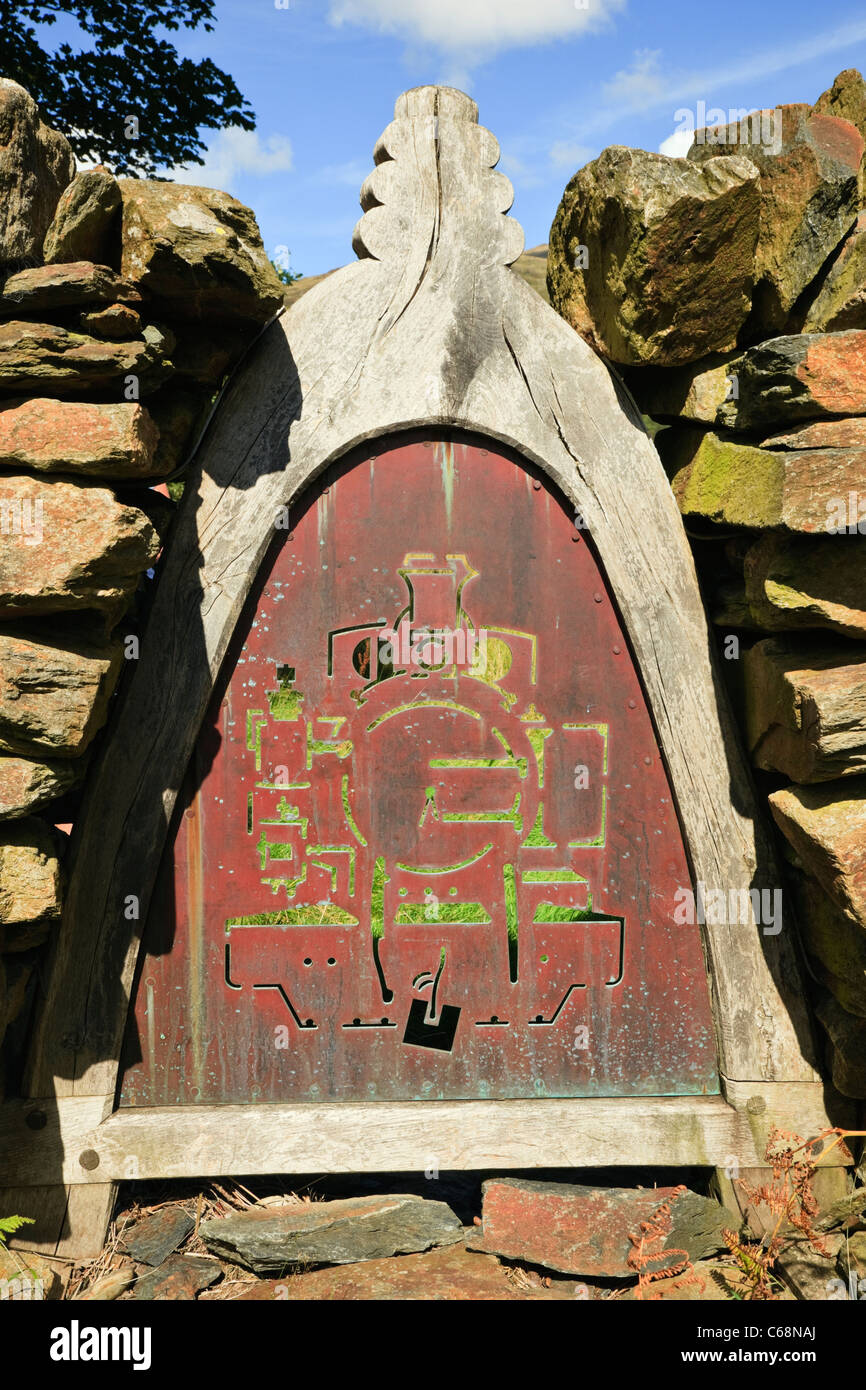 Steinmauer mit verzierten Metallplatte mit Dampflok übersicht Eröffnung der Welsh Highland Railway in Gwynedd Beddgelert Wales UK zu gedenken. Stockfoto