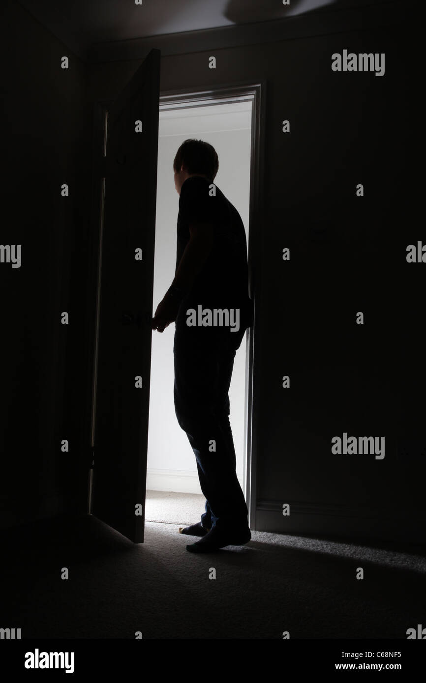 Silhouette eines Mannes verlassen eines dunklen Raumes. Stockfoto
