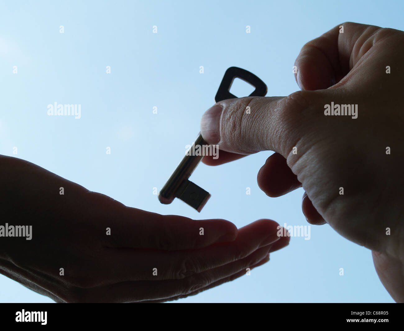Ein Schlüssel Wird von Einer Hand in Eine Andere Hand Gegeben | Ein Schlüssel wird aus einer Hand eine andere Hand gegeben Stockfoto