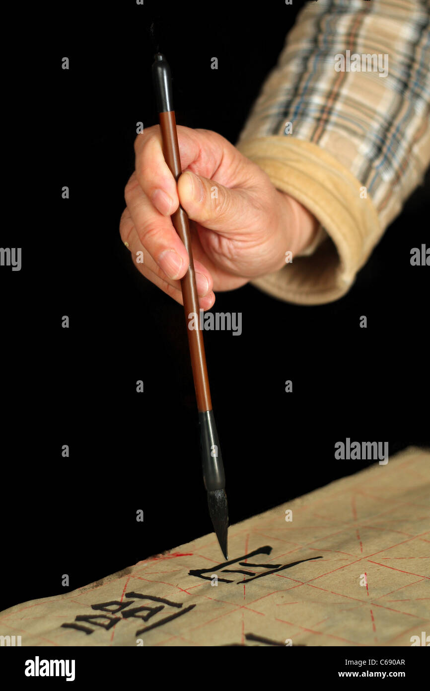 Ein Alter Mann ist Callingraphy mit einem Pinsel-Stift in seiner Freizeit üben. Stockfoto