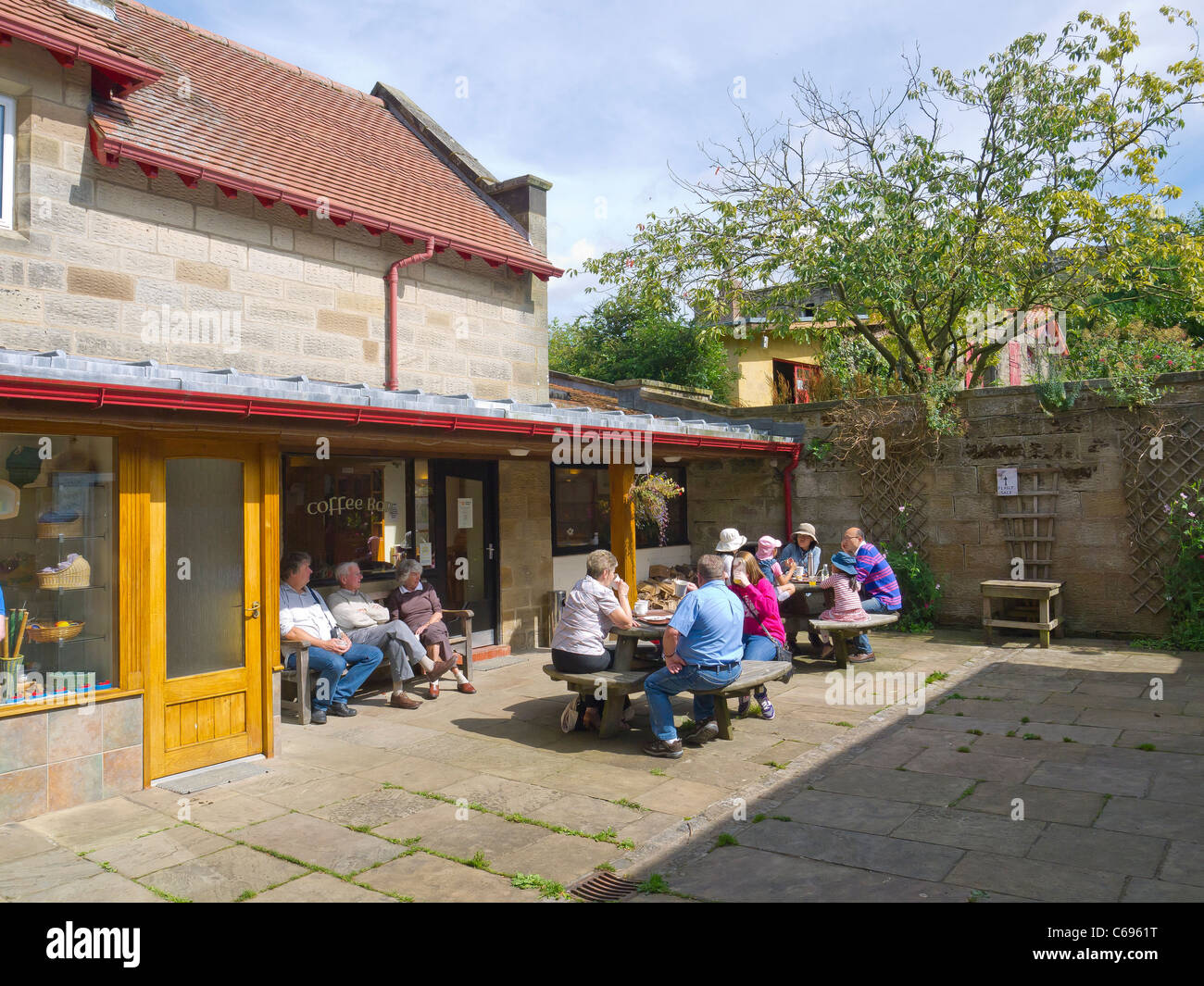 Bewohner und Besucher genießen die Sommersonne an der Kaffeebar in Botton Dorf, ein Camphill Village Vertrauen Heim für Behinderte. Stockfoto