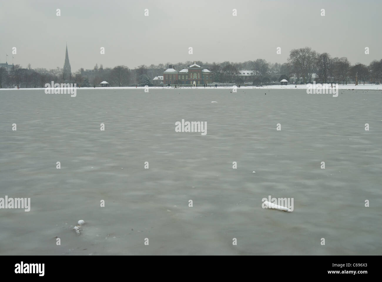 Runden Teich im Londoner Hyde Park Blick auf Kensington Palace im Winter nach Schneefällen Stockfoto