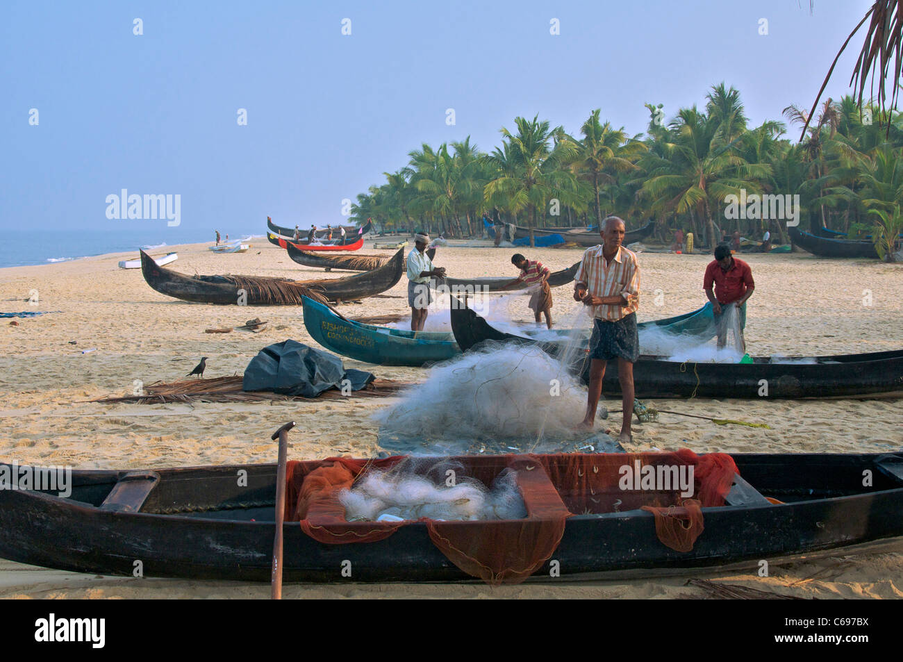 Fischer, die Sortierung Fischernetze auf Marari Beach Kerala Süd-Indien Stockfoto