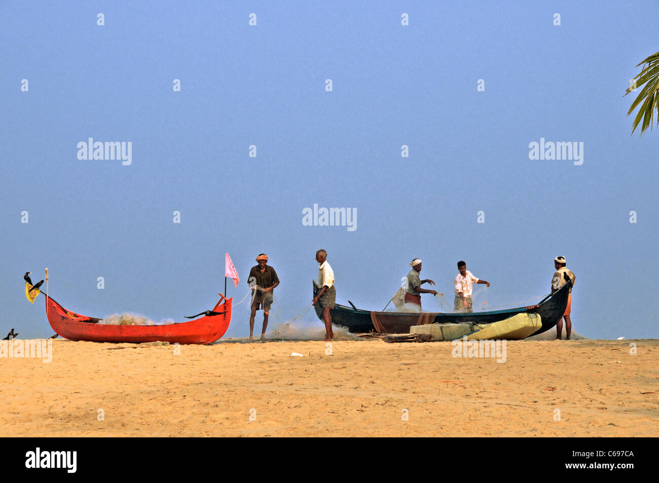 Fischer, die Sortierung Fischernetze auf Marari Beach Kerala Süd-Indien Stockfoto