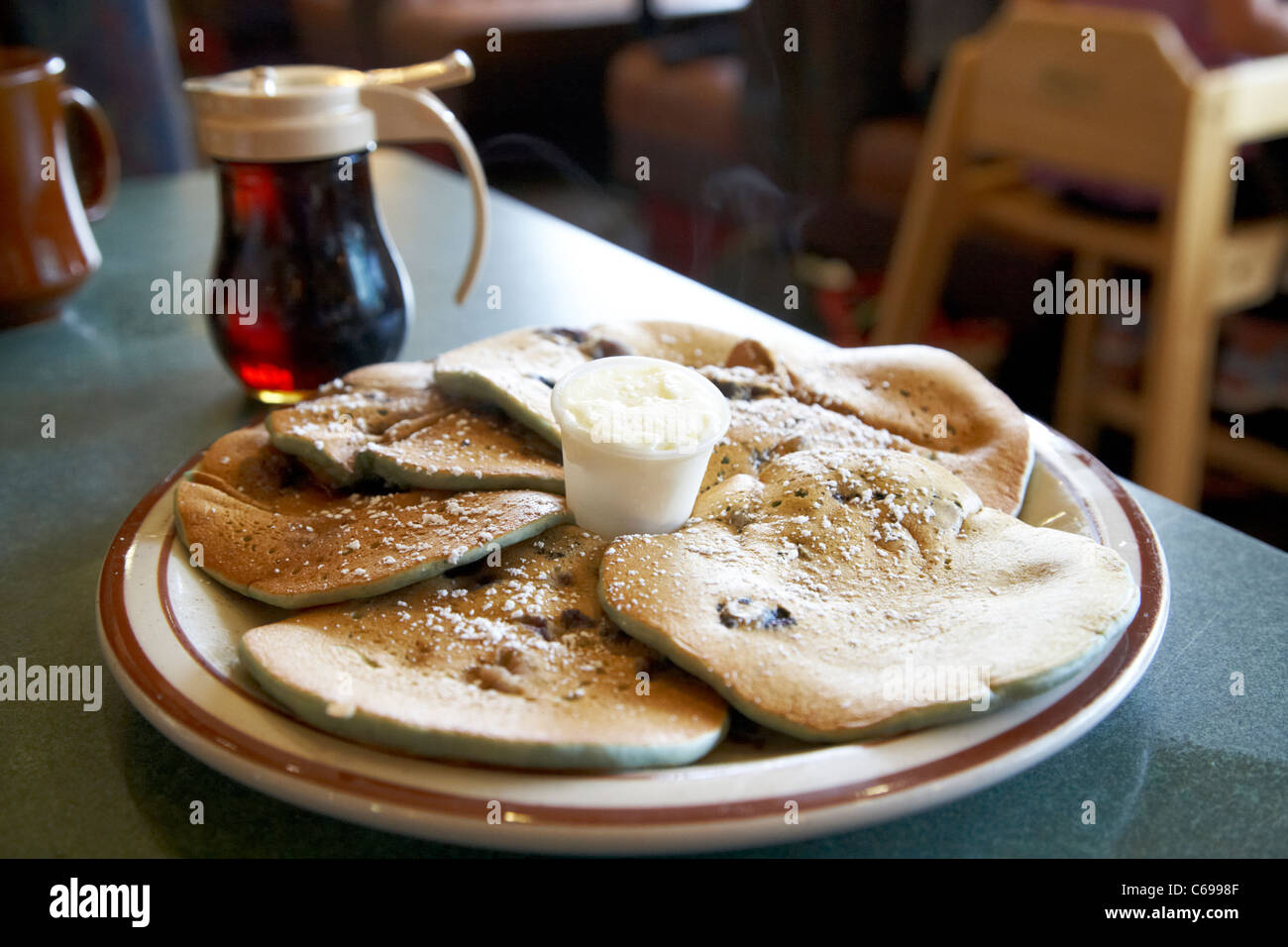 Teller mit frisch zubereiteten Blaubeerpfannkuchen Schlagsahne Butter und Ahornsirup in einem Café in Kanada Stockfoto