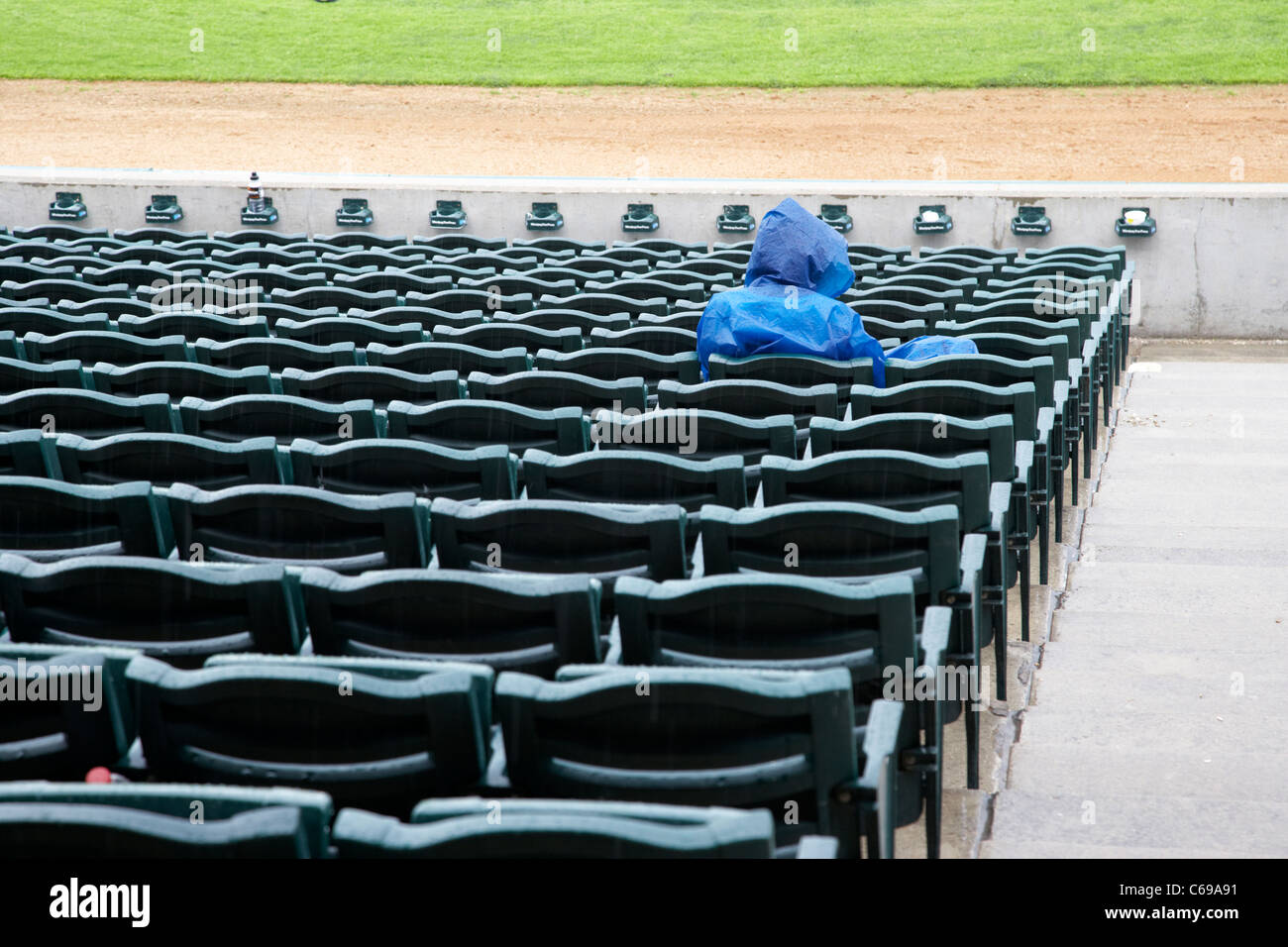 Zuschauer in Regenmantel im Stand bei Regen im Shaw Park Baseball Stadium sitzen früher Canwest Heimat Winnipeg Goldeyes Stockfoto
