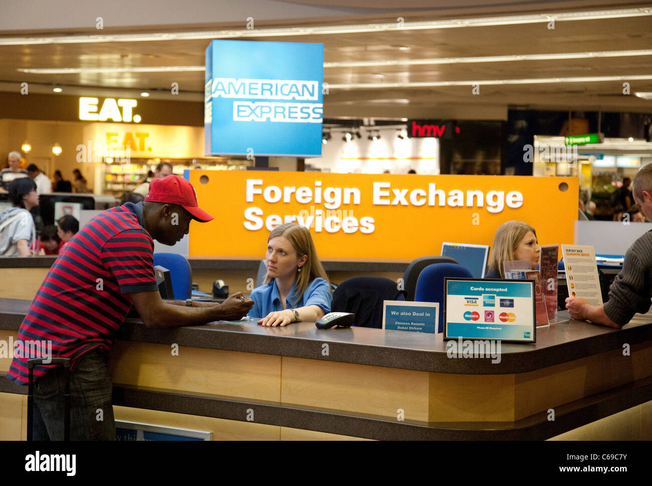 Ein Mann immer Ratschläge von American Express Services in der Abflug-Lounge, Terminal 3, Heathrow Flughafen London UK Stockfoto
