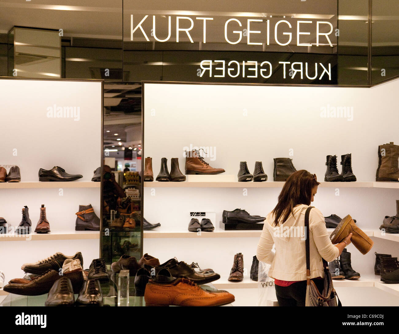 Shopping für Schuhe im Shop Kurt Geiger, terminal 3, Heathrow Flughafen London UK teenager Stockfoto