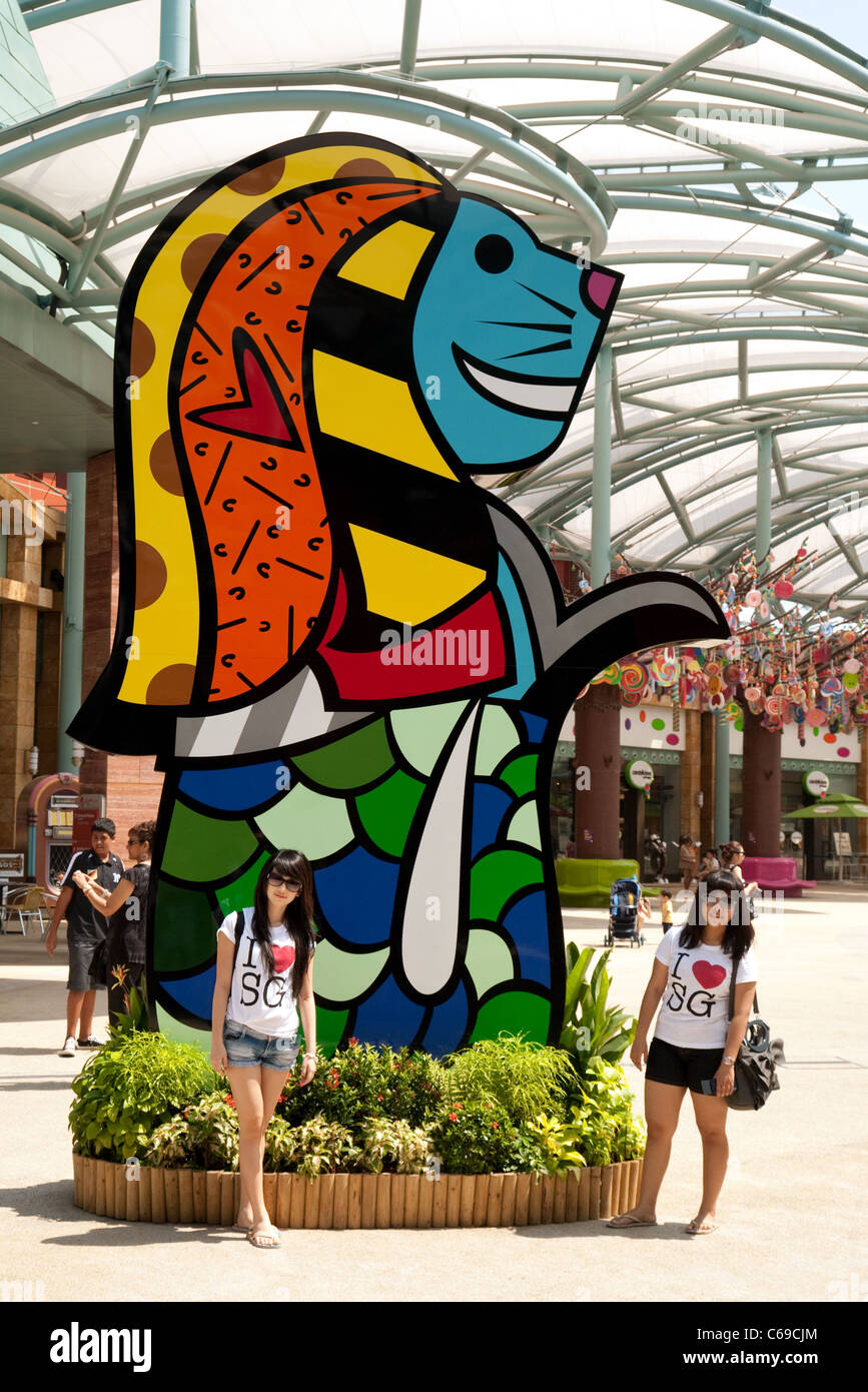 Zwei lokale Mädchen posieren vor eine Anpassung der Merlion, Singapurs Symbol in den Universal Studios Singapur Stockfoto
