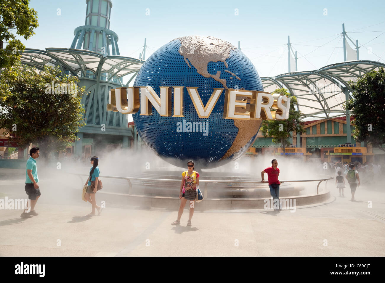 Touristen, die mit dem Universal Studios Globus, Sentosa Island, Universal Studios Singapur Asien posiert Stockfoto