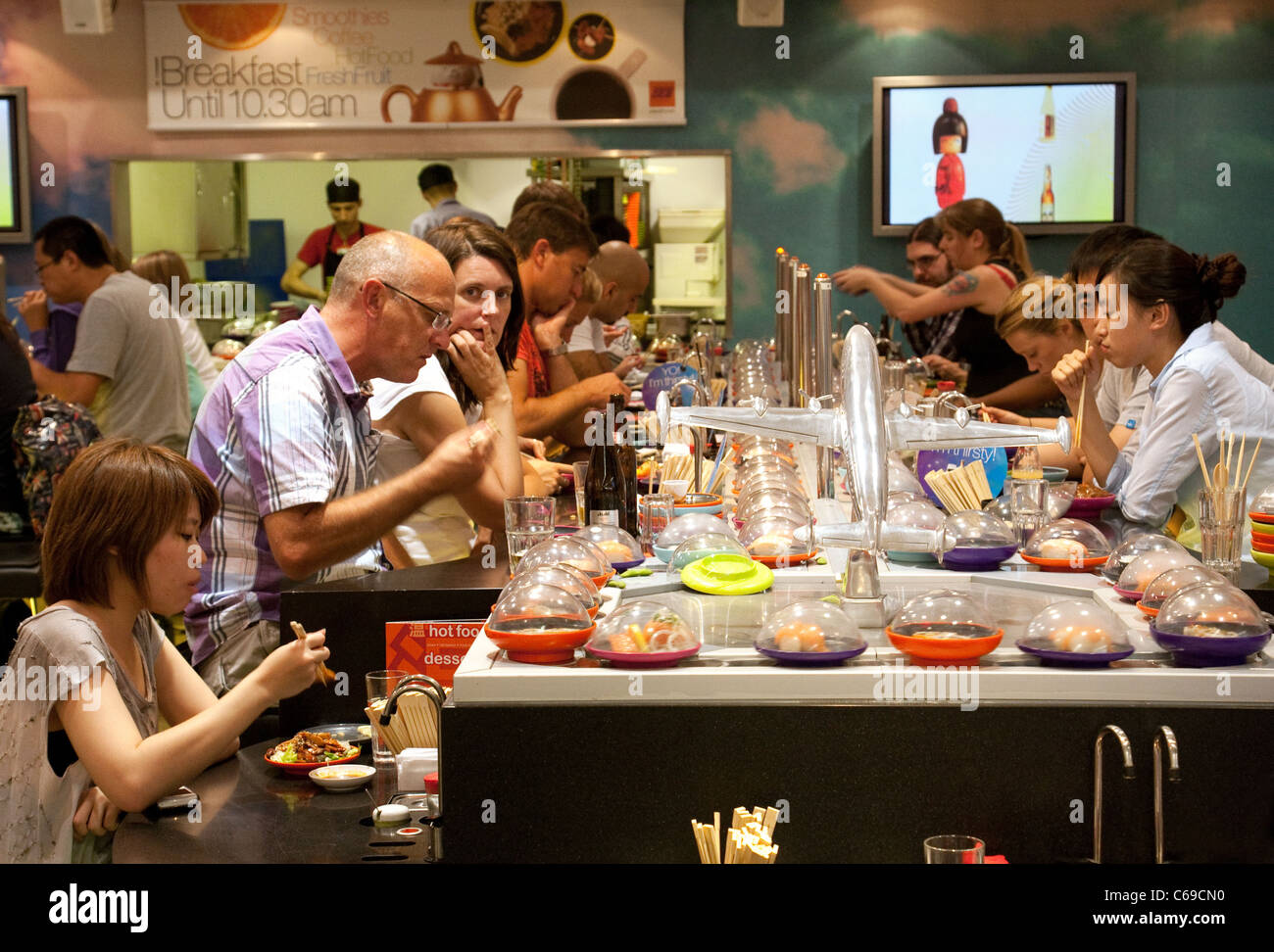 Menschen essen, Sushi, Yo Sushi Restaurant, terminal 3, Flughafen Heathrow, London UK Stockfoto