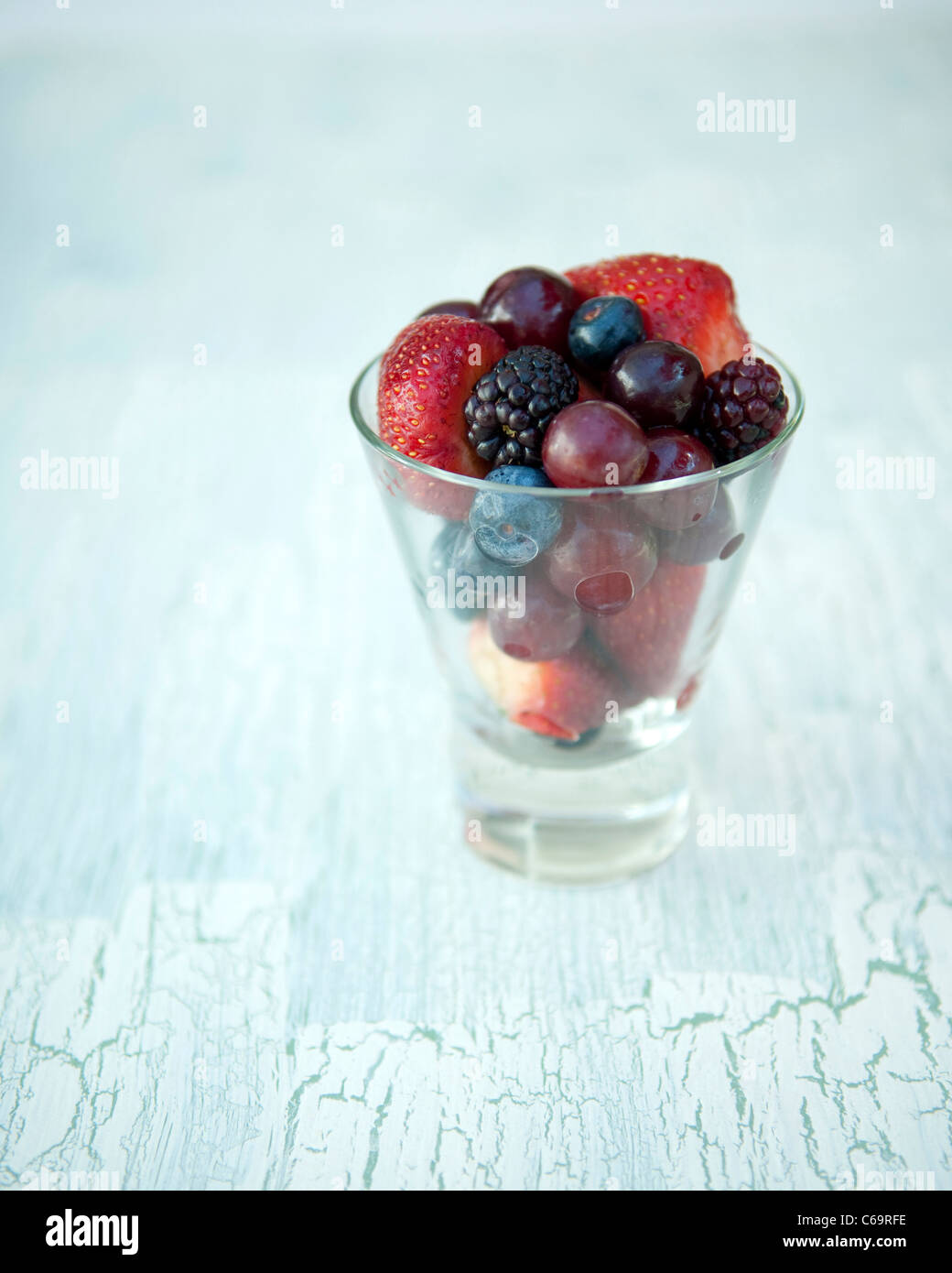 Trauben, Erdbeeren, Brombeeren und Heidelbeeren im Glas Stockfoto