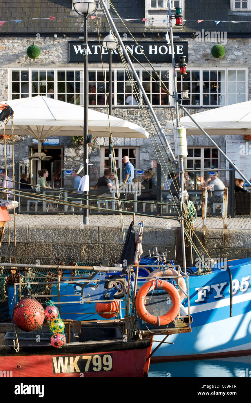 Die blaue-weiße Rumpf des FY95 Fischerboot und The Watering Hole spiegelt sich in dem Wasser bei Sutton Harbour, Barbican, Plymouth. Stockfoto