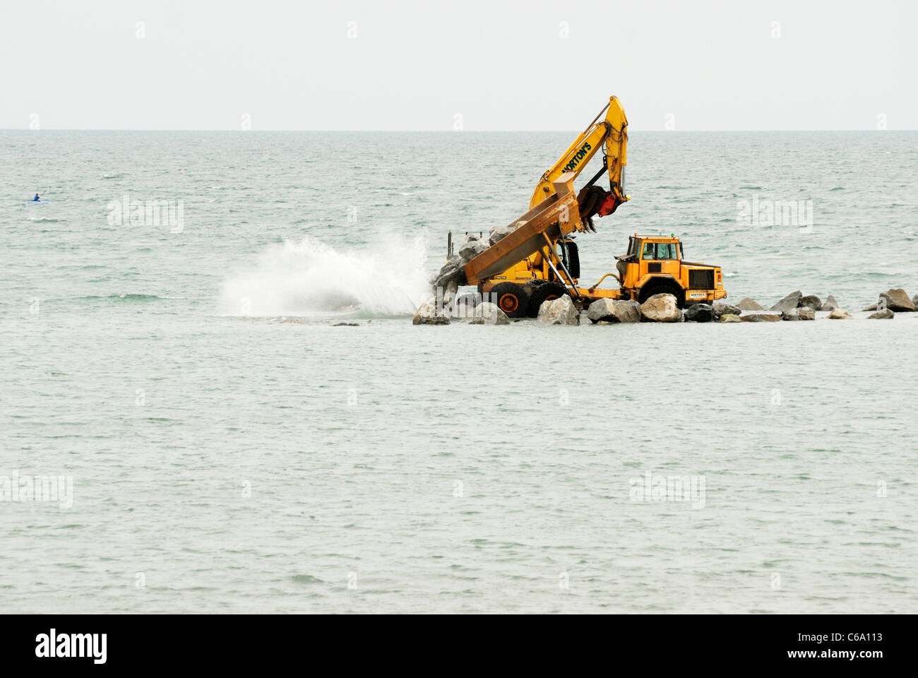 LKW Kipp Stein für den Bau von ein künstliches Riff, Abwehrkräfte Teil des Meeres für das Dorf von Borth, Ceredigion, Wales Stockfoto