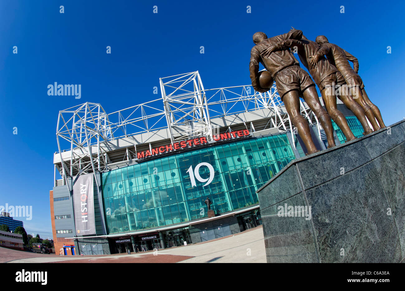 Haupteingang des Manchester United FC Boden in Old Trafford in Manchester zeigt die Statue der "Heiligen Dreifaltigkeit" Stockfoto