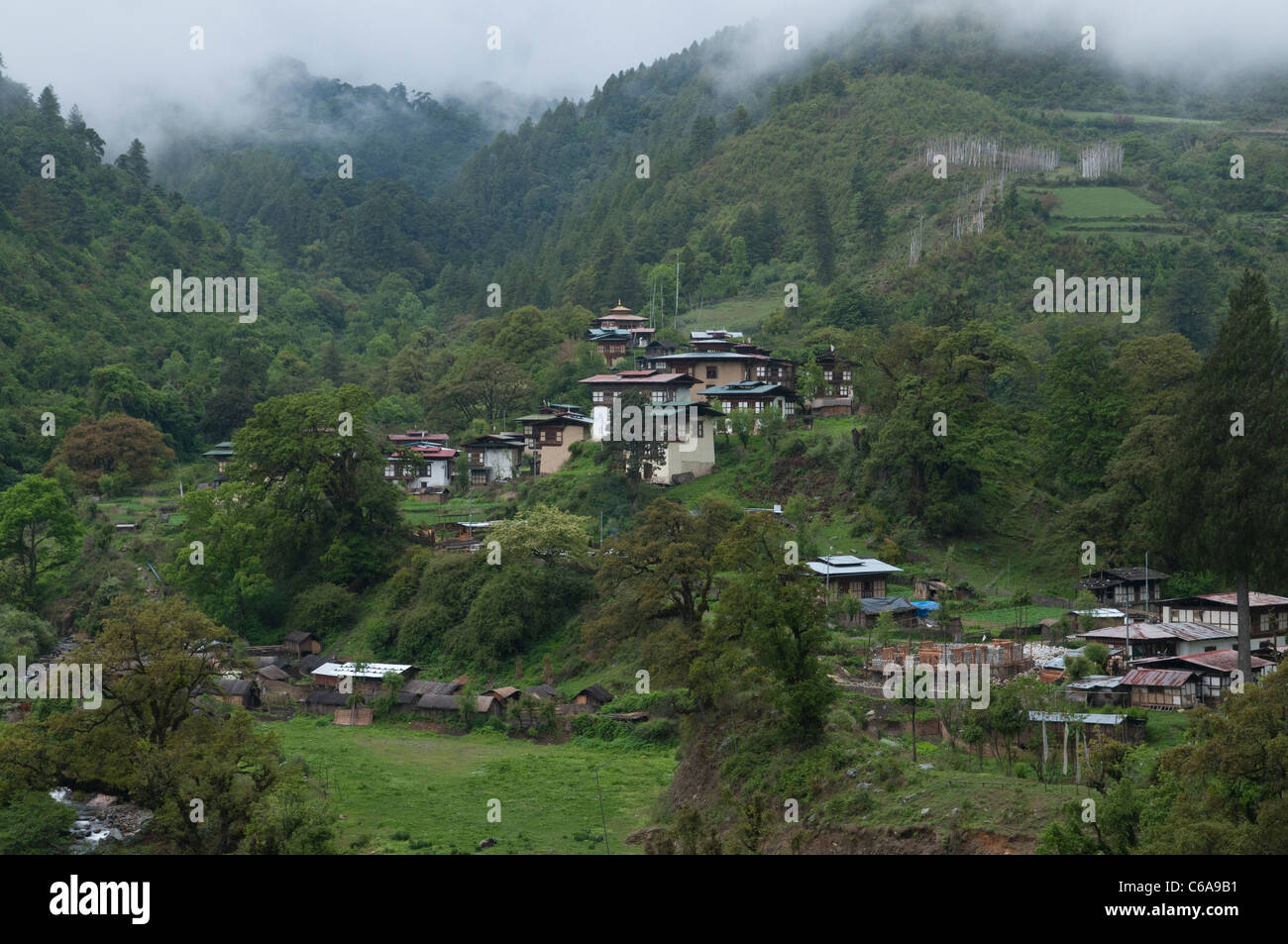 Blick auf typischen Dorf umgeben von Hügeln und Wäldern. Bhutan Stockfoto