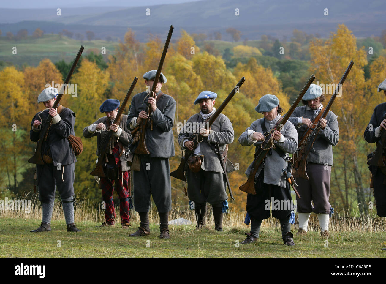 Mitglieder des [Frasers Dragoner], ein 17. Jahrhundert Reenactment Gesellschaft, laden ihre Musketen Stockfoto