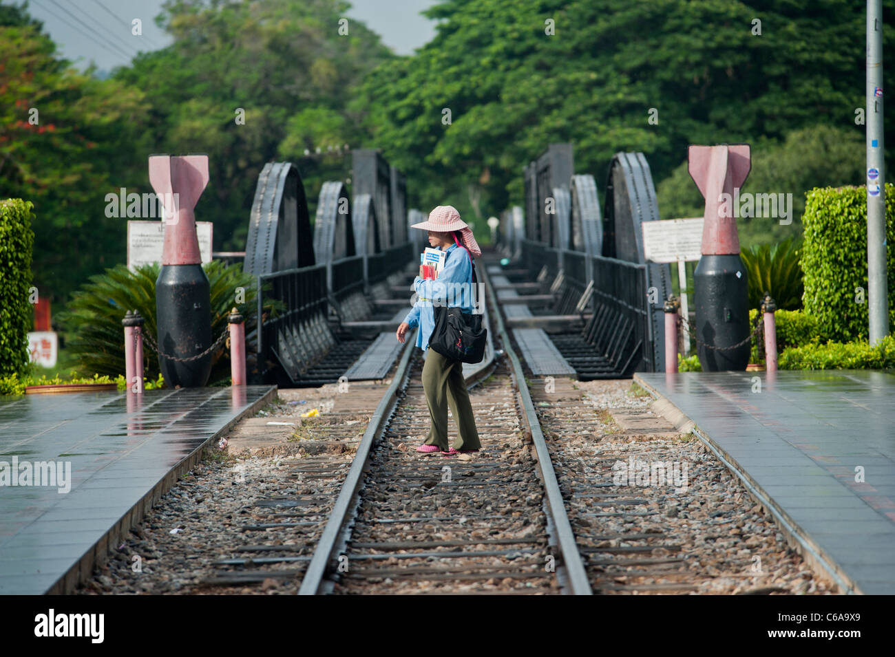 Eine Frau kreuzt den River Kwai Bridge und Eisenbahn Kanachanaburi, Thailand Stockfoto