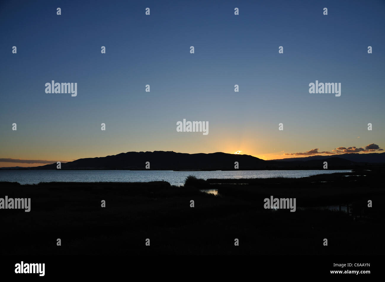 Sonnenuntergang. L'Encanyissada Lagune (El Montsià Berge im Hintergrund). Ebro-Delta. Provinz Tarragona. Spanien Stockfoto