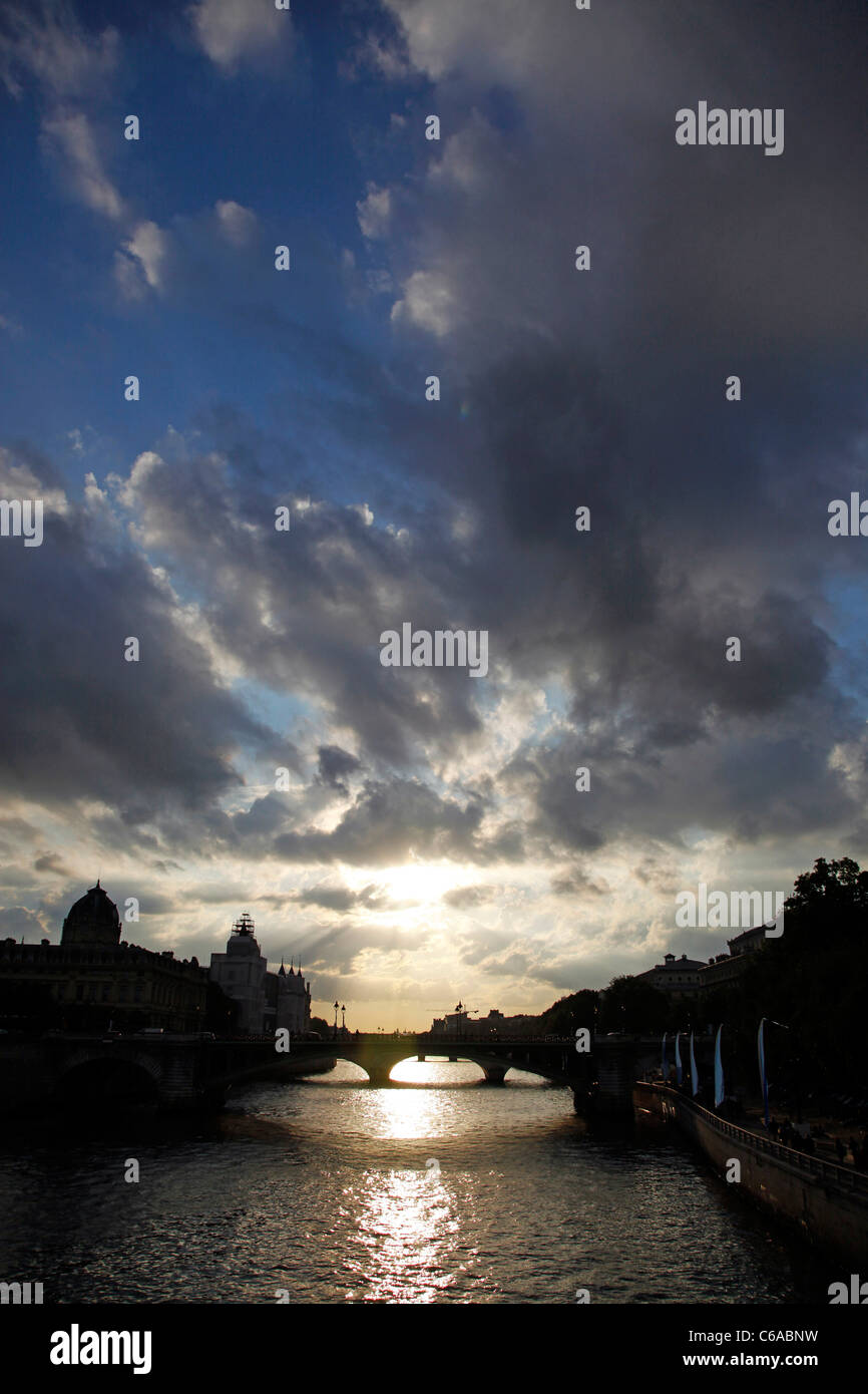 Stürmischer Himmel bei Sonnenuntergang mit Skyline Silhouette über dem Fluss Seine in Paris, Frankreich Stockfoto