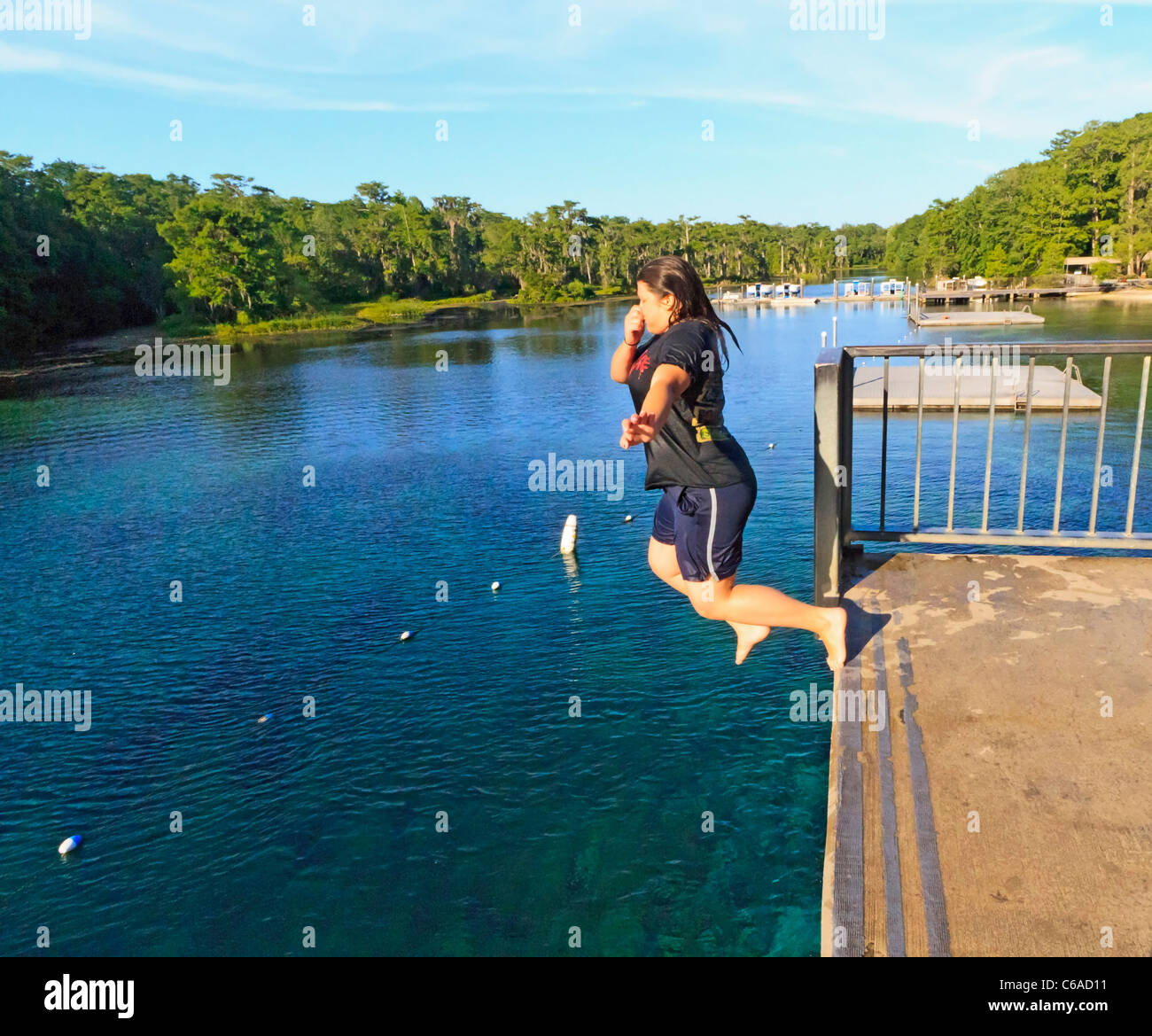 Junge Frau springt in Wakulla Frühling von hohen Plattform Stockfoto