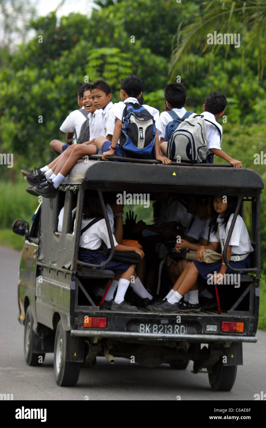 Schulkinder in einheitlichen inneren und auf der Oberseite einen Minivan, wobei sie die Schule in Bukit Lawang Stockfoto