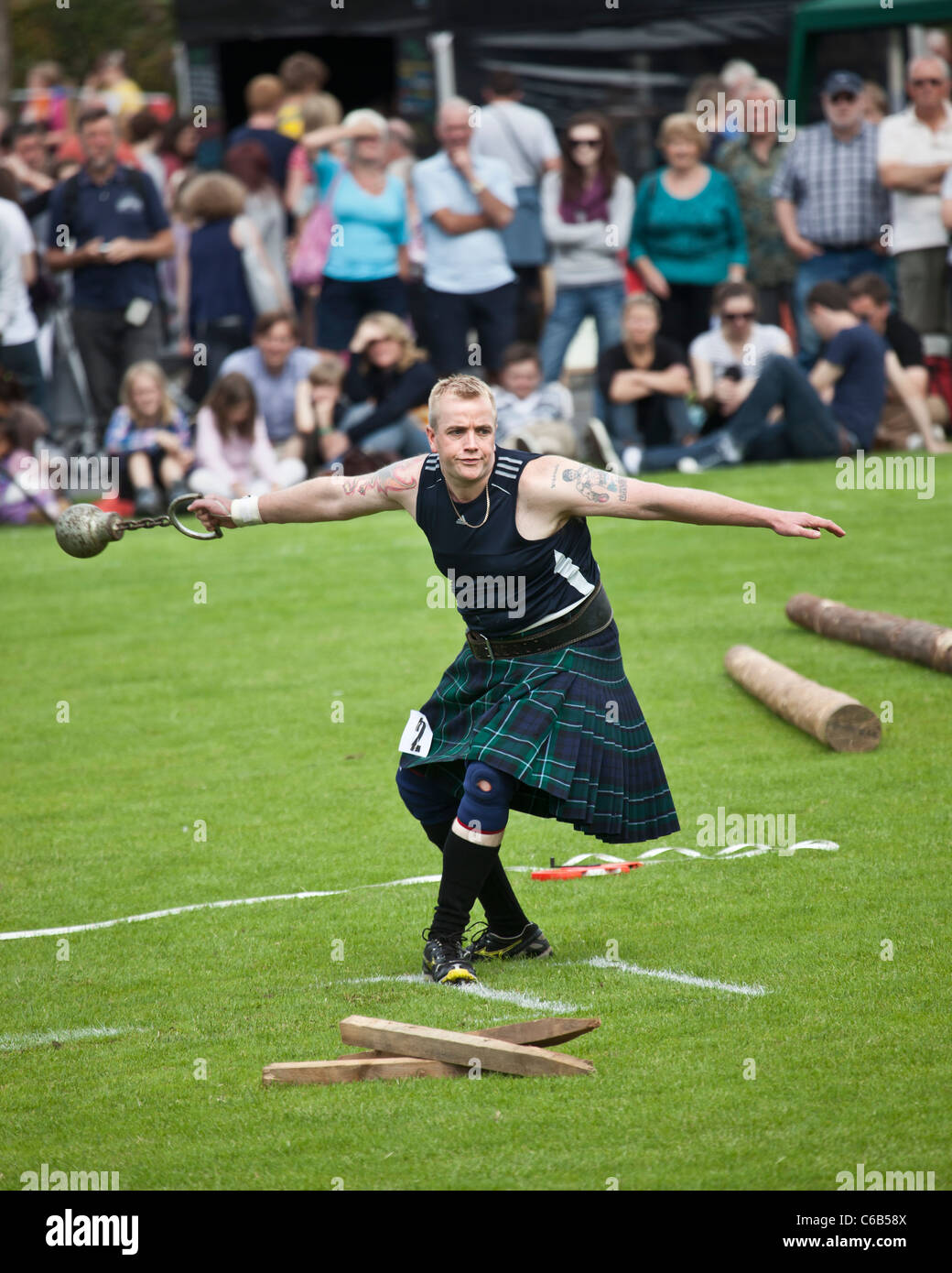 Kilted Athlet im Wettbewerb 'werfen ein 28lb' Gewicht während eines der "schwere Ereignisse" bei Brodick Highland Games, Arran Stockfoto