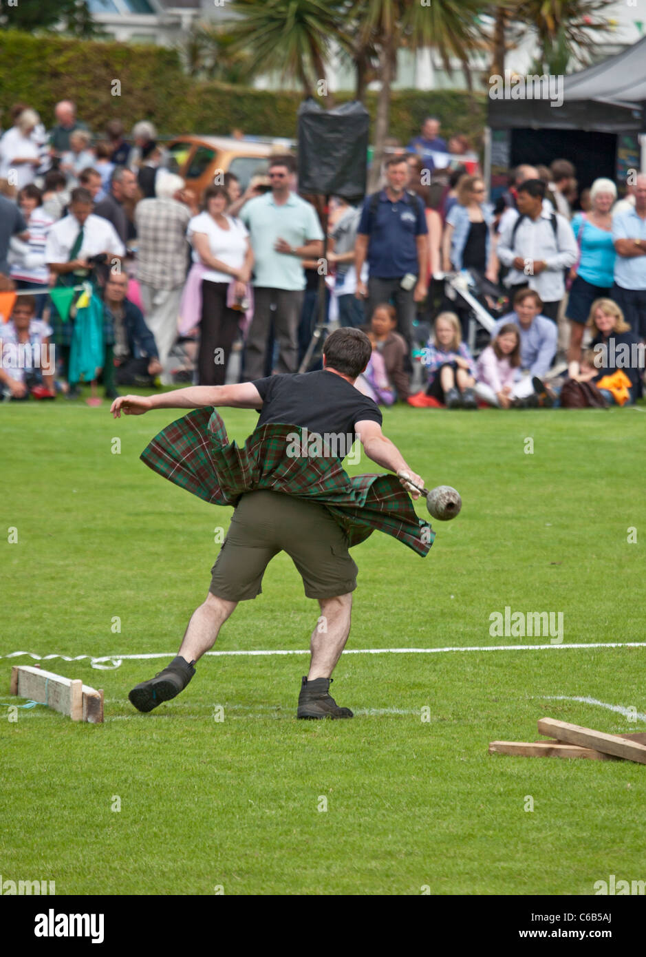 Kilted Athlet im Wettbewerb 'werfen ein 28lb' Gewicht während eines der "schwere Ereignisse" bei Brodick Highland Games, Arran Stockfoto