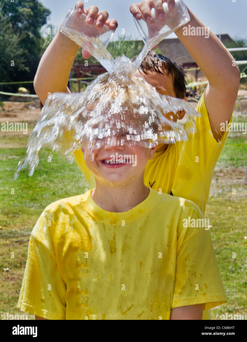 Preteen Boy hat kaltes Wasser übergossen sich an einem heißen Nachmittag in Orange, Kalifornien. Stockfoto