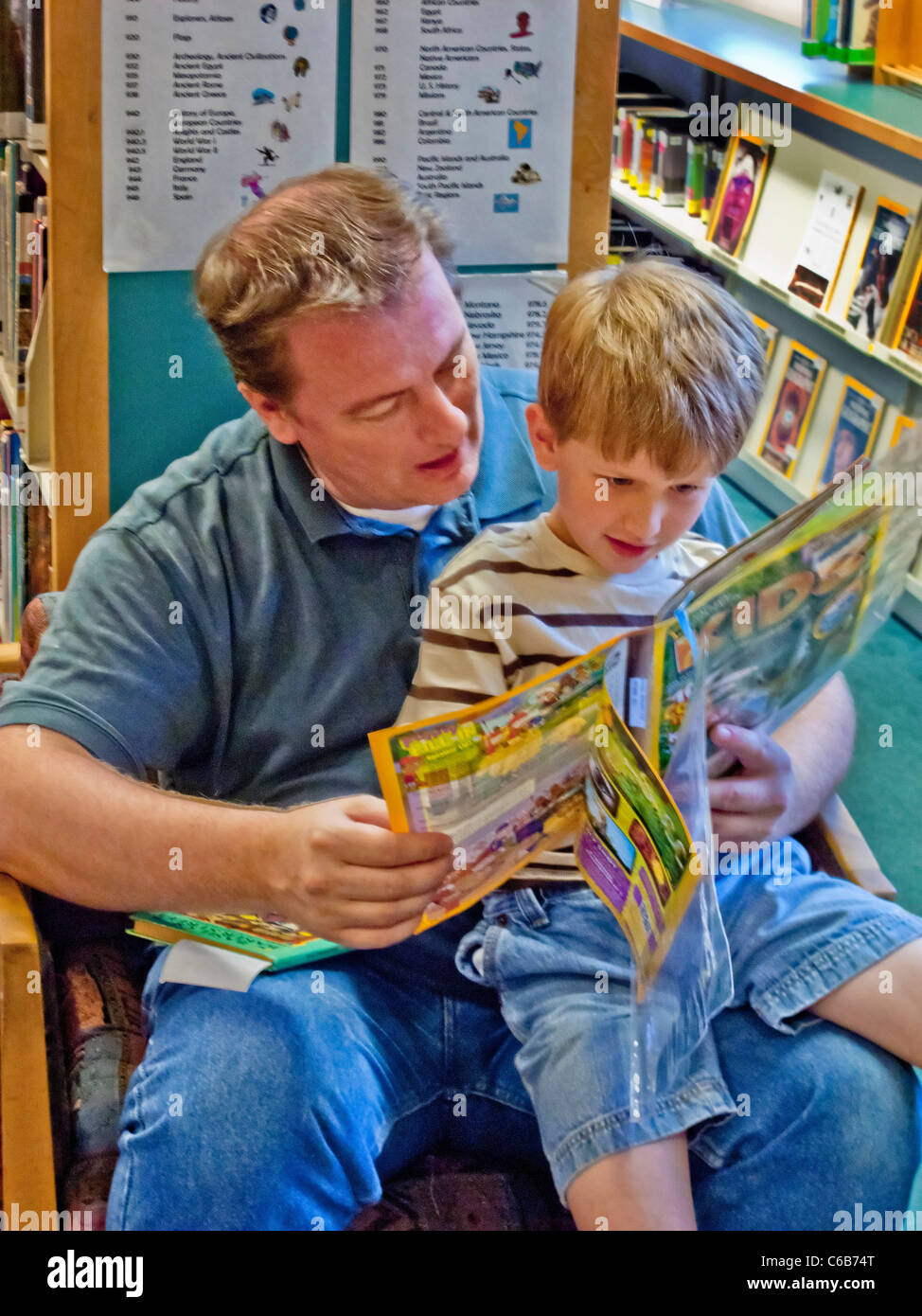 Ein Kinder Magazin in einer öffentlichen Bibliothek in Aliso Viejo, CA liest ein Vater an seinen Sohn. Stockfoto