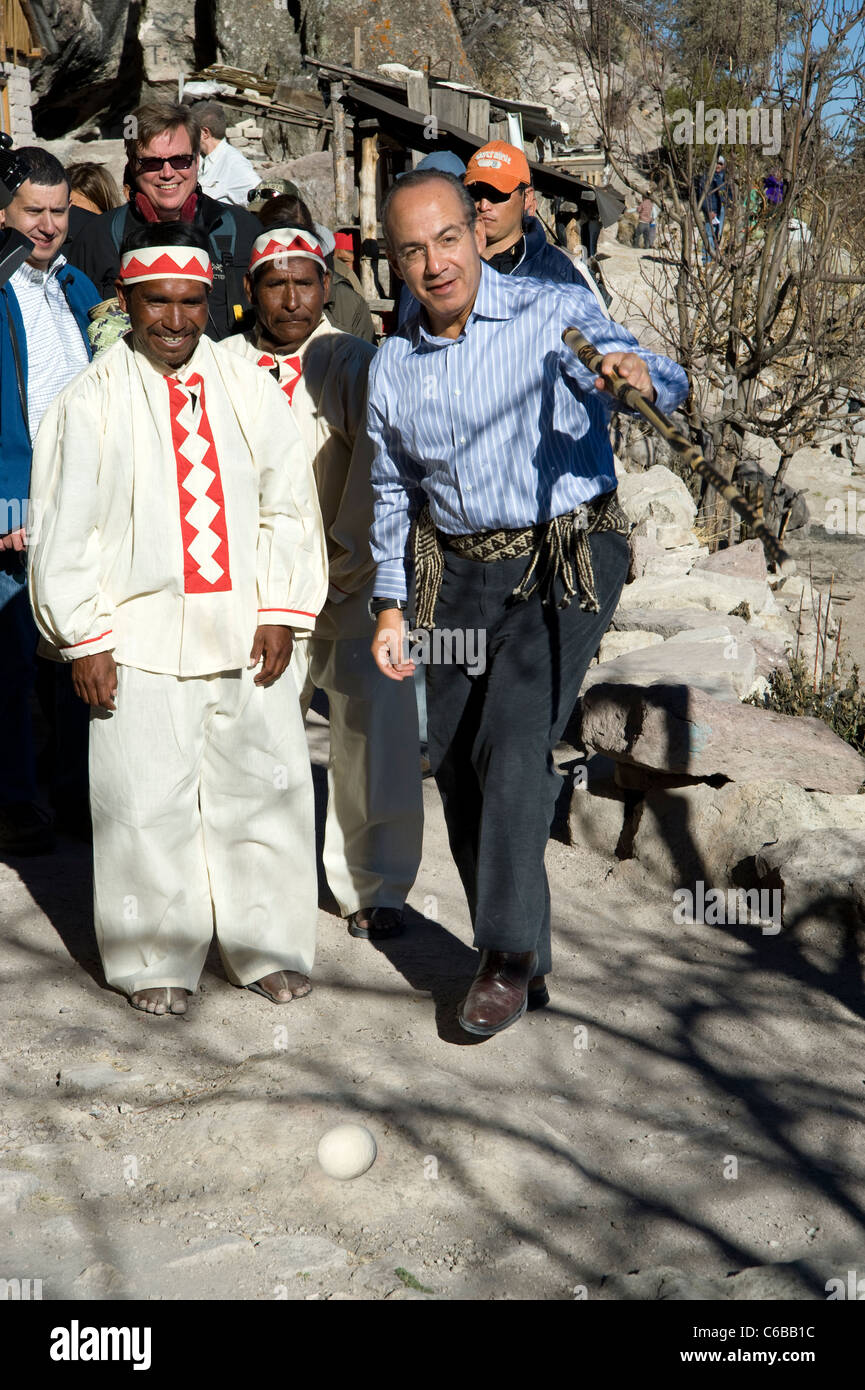 Präsident Calderon probiert ein Spiel mit einem Stock und einen Ball mit einheimischen Menschen am Rand der Copper Canyon in Mexiko Stockfoto