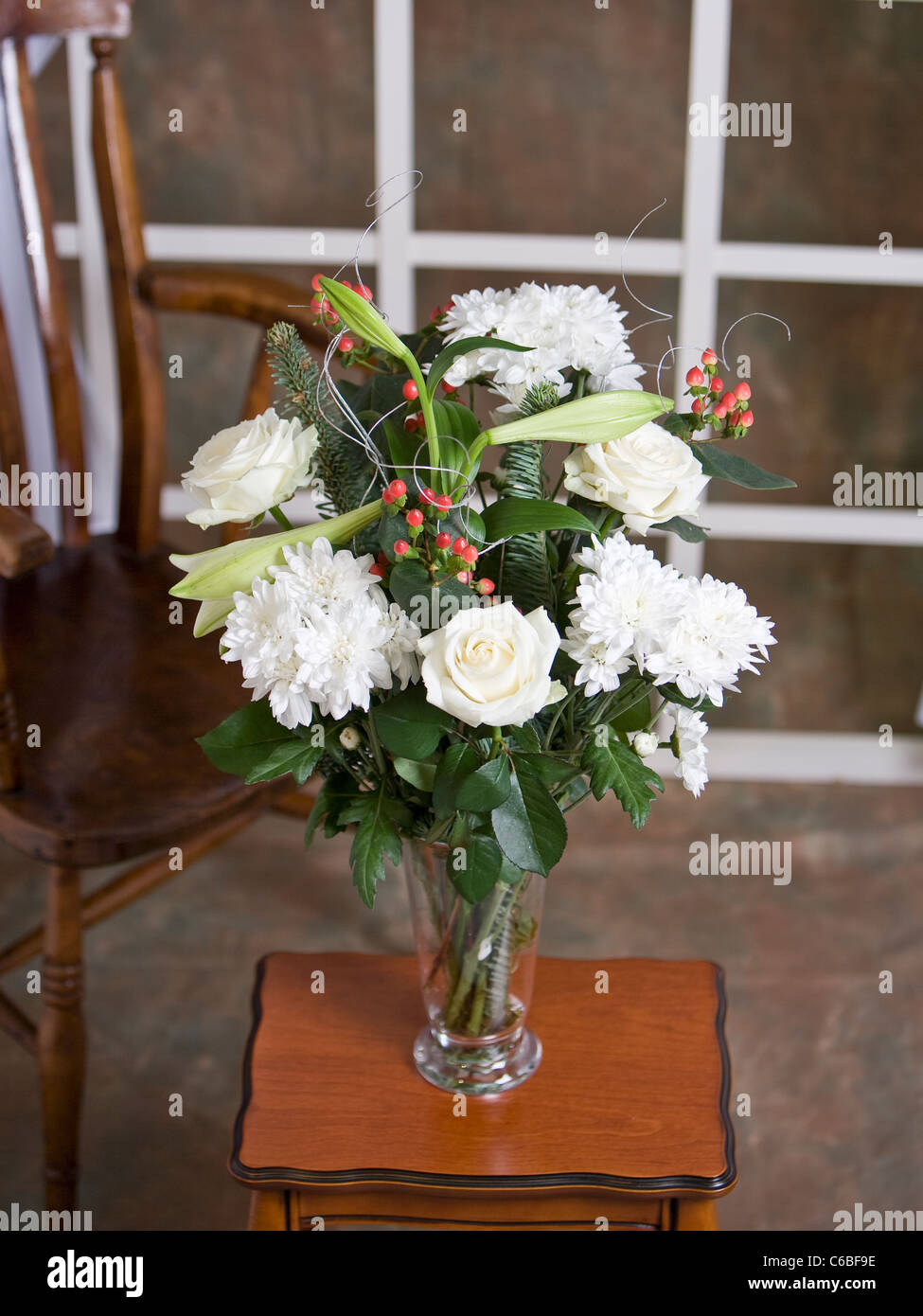 Ein Bouquet aus weißen Rosen. weiße Chrysanthemen, Lilien, roten Beeren und Dekoration Stockfoto