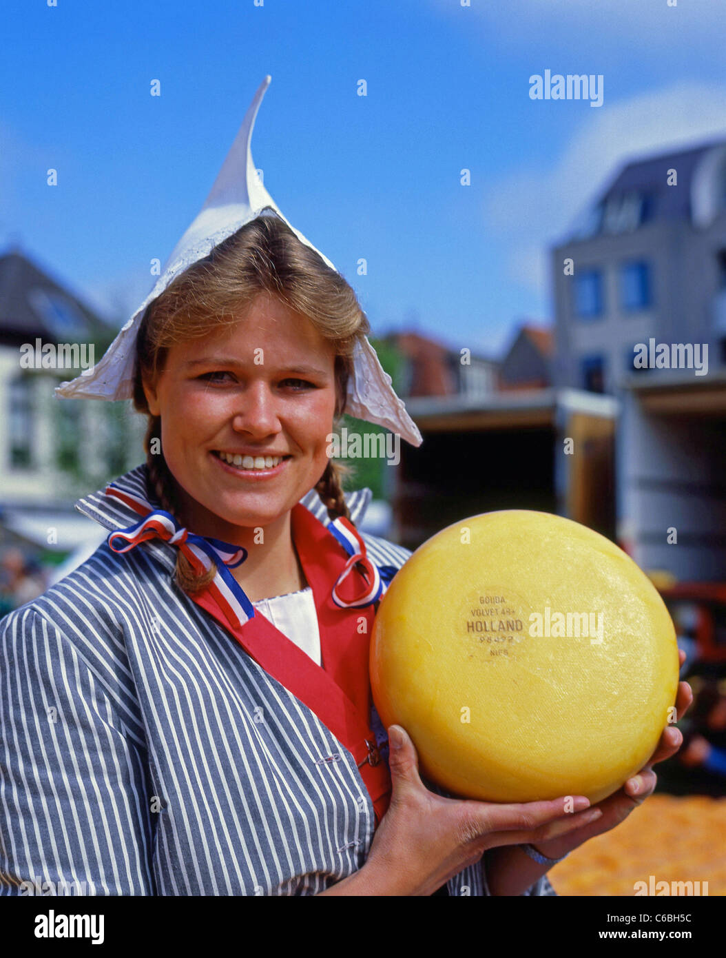 Junge Frau mit Rad von Gouda Käse in Alkmaar Käsemarkt, Alkmaar, Noord Holland, Königreich der Niederlande Stockfoto