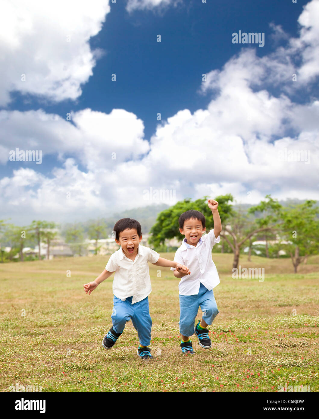 gerne asiatische Kinder laufen auf dem Rasen Stockfoto