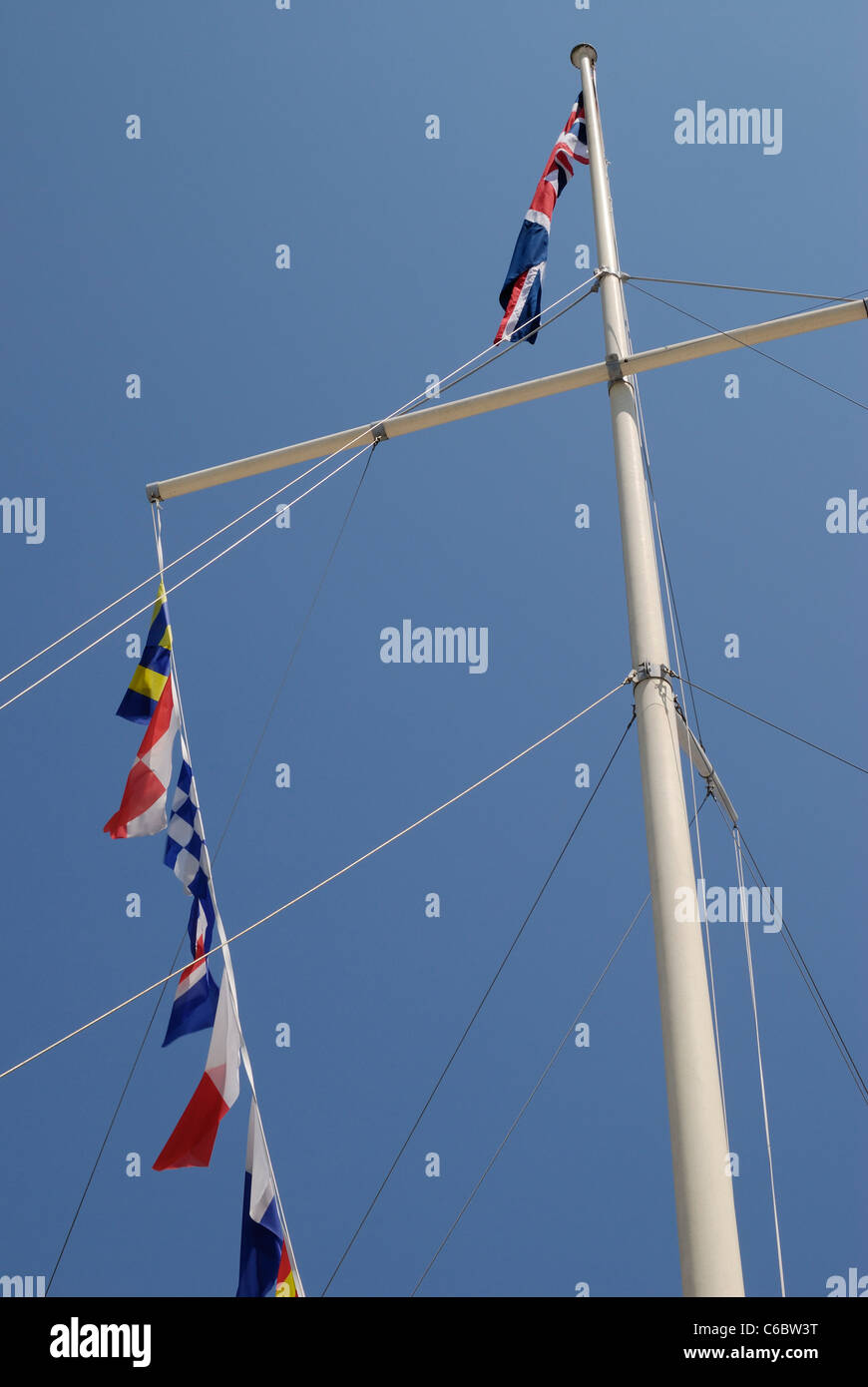 Verschiedene Flaggen von Fahnenmast vor einem strahlend blauen Himmel fliegen Stockfoto