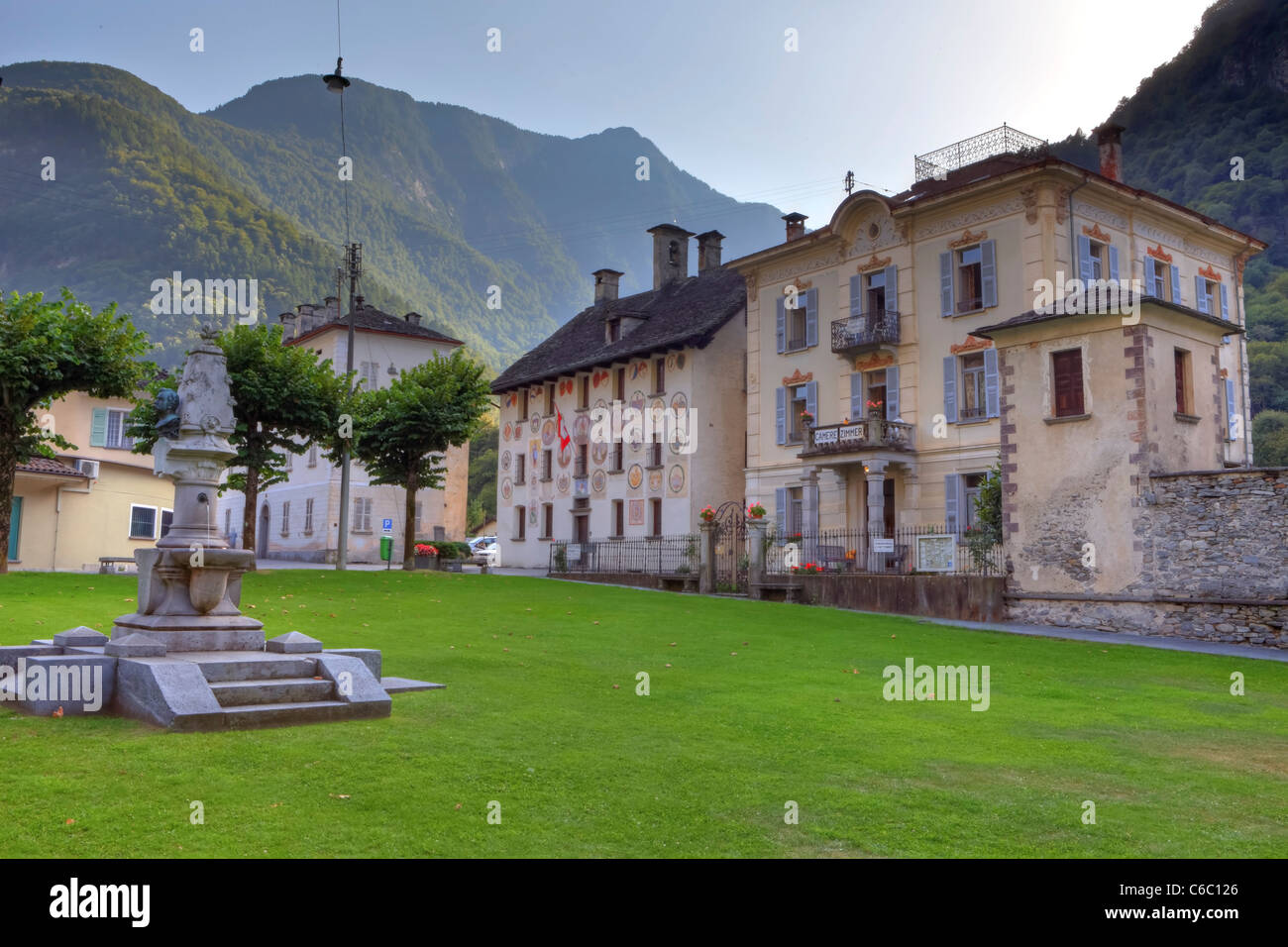 Der Dorfplatz mit Brunnen und Skulpturen in Cevio, Vallemaggioa, Tessin, Schweiz Stockfoto