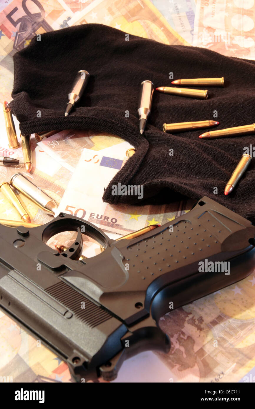 Sturmhaube Geld Pistole und Kugeln zeigt ein Konzept einer Bank-Räuber oder Terroristen-Tätigkeit Stockfoto